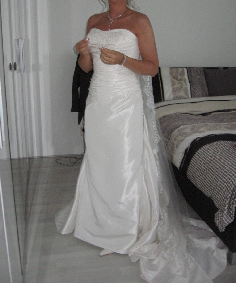 Prachtige satijnen bruidsjurk, met een lange sluier van kant