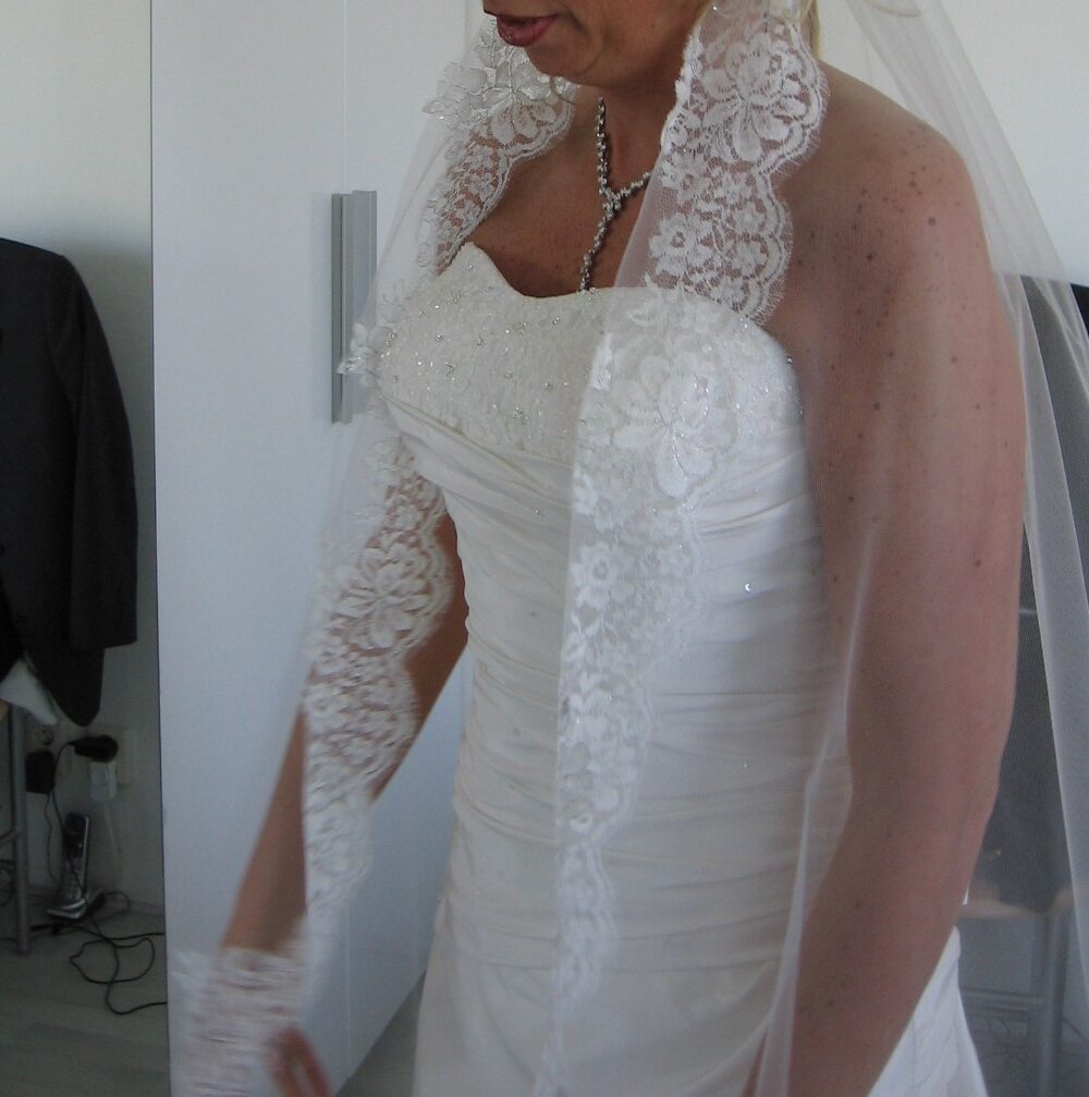 Prachtige satijnen bruidsjurk, met een lange sluier van kant