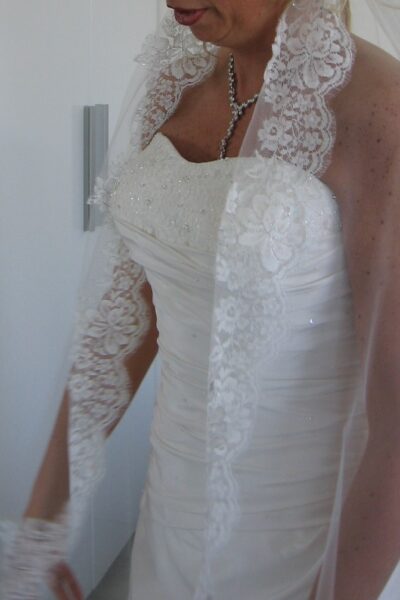 Prachtige satijnen bruidsjurk, met een lange sluier van kant