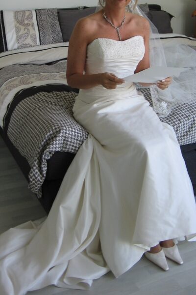 Prachtige satijnen bruidsjurk, met een lange sluier van kant